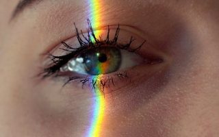 anonymous woman with rainbow light on face